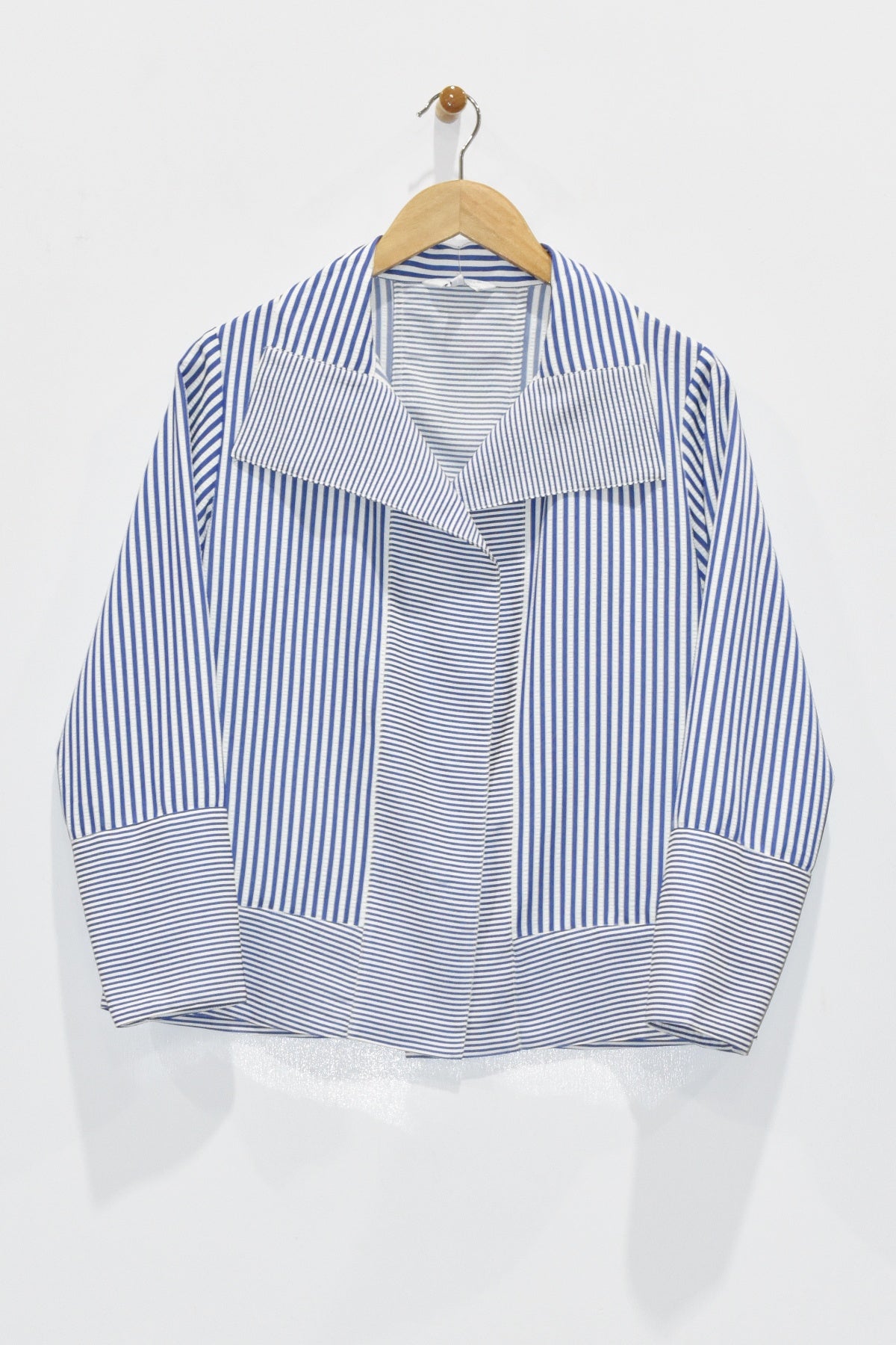 Blue and white striped shirt on a hanger against a white background