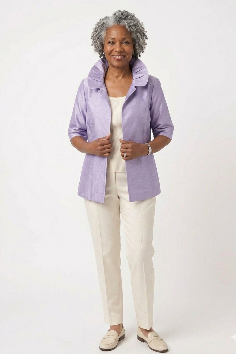 Woman wearing a light purple jacket over a white top and pants on a white background
