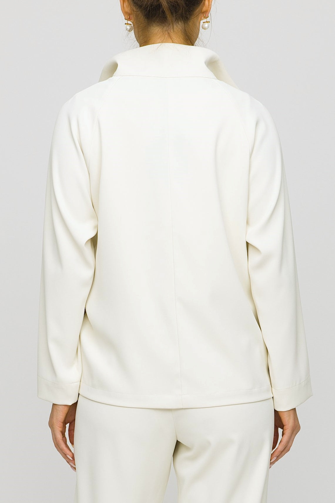 Person wearing a white outfit against a plain background