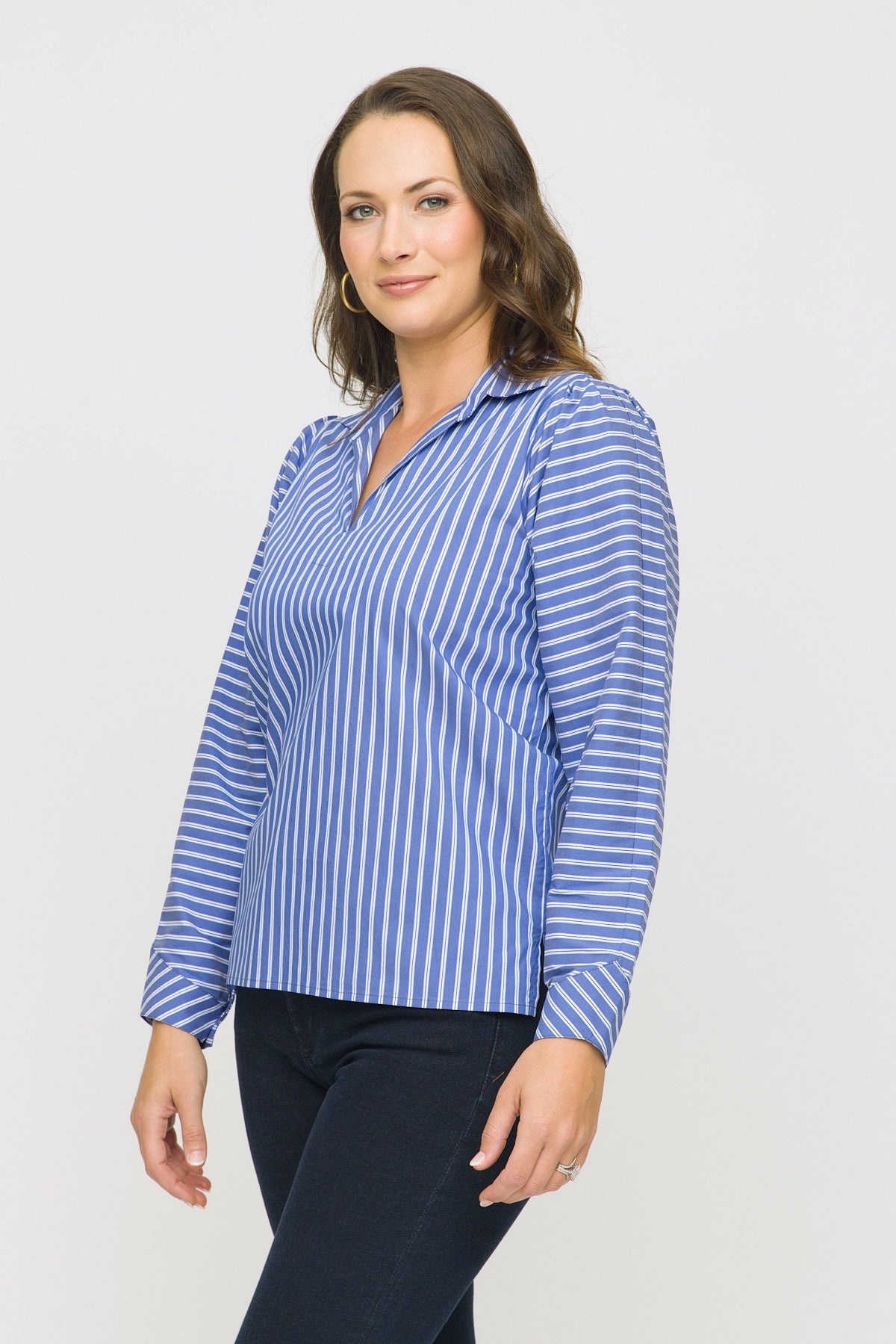 Woman wearing a blue and white striped shirt against a plain background