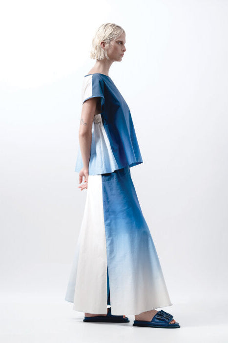 Woman wearing a blue and white outfit on a plain background